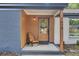 Close up shot of single-story home featuring a cozy front porch with a wooden chair at 7674 Chippendale Rd, North Charleston, SC 29420
