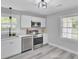 Modern kitchen featuring stainless steel appliances, white cabinetry, and stylish fixtures. Large window over sink at 7674 Chippendale Rd, North Charleston, SC 29420