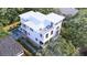 Stunning aerial view of a three-story house surrounded by lush greenery and a privacy fence at 814 Palm Blvd, Isle of Palms, SC 29451