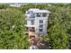 Aerial view of a modern home surrounded by lush greenery and mature trees in a neighborhood setting at 814 Palm Blvd, Isle of Palms, SC 29451