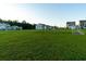 A grassy open community backyard featuring green grass and row of houses in the background at 9747 Seed St, Ladson, SC 29456