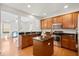 Spacious kitchen with island, granite countertops, wood cabinets, and stainless steel appliances at 9747 Seed St, Ladson, SC 29456