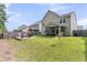 The backyard features a fire pit, screened-in porch, and lush lawn, ideal for outdoor gatherings and leisure at 9829 English Elm St, Ladson, SC 29456