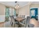 Elegant dining room featuring a wood table, upholstered chairs, modern light fixture, and decorative window treatments at 9829 English Elm St, Ladson, SC 29456