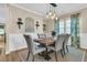 Stylish dining room with wainscoting, a rustic wood table, elegant chairs, and modern light fixture at 9829 English Elm St, Ladson, SC 29456