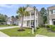 Two-story home with a second story porch, palm tree, and neatly landscaped front yard showcases curb appeal at 9829 English Elm St, Ladson, SC 29456