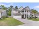 Charming two-story home with a two-car garage, a second story porch and landscaped front yard at 9829 English Elm St, Ladson, SC 29456