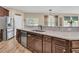Kitchen peninsula featuring granite counters, dark cabinetry, stainless dishwasher, and a view of the yard and neighborhood at 9829 English Elm St, Ladson, SC 29456
