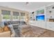 Bright living room with built-in shelving, a large sectional sofa, plush rug, and ample natural light at 9829 English Elm St, Ladson, SC 29456