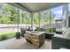 Inviting screened-in porch with comfortable seating, and a unique wooden log coffee table overlooking the backyard at 9829 English Elm St, Ladson, SC 29456