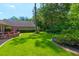 Well-manicured backyard featuring lush green grass, mature landscaping, and brick retaining wall at 101 Firestone Ct, Summerville, SC 29483