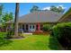 Expansive backyard with brick accents, a well-maintained lawn, and mature trees offering privacy and shade at 101 Firestone Ct, Summerville, SC 29483