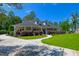 Inviting Southern home boasting a covered porch, manicured landscaping, lush green lawn, and mature trees at 101 Firestone Ct, Summerville, SC 29483