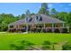 Inviting single-story home with a wide porch, lush lawn, and colorful shrubs at 101 Firestone Ct, Summerville, SC 29483