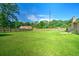 Expansive backyard with a wooden fence, ample green space, and mature trees at 101 Parkside Dr, Goose Creek, SC 29445