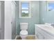 Bathroom featuring a toilet, white vanity, window and enclosed shower, creating a clean and functional space at 101 Parkside Dr, Goose Creek, SC 29445