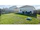 Green backyard with a trampoline, fence, and dog house on a sunny day at 1014 Peridote Way, Ladson, SC 29456