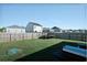 A large backyard with a wooden fence, trampoline, and green turtle toy at 1014 Peridote Way, Ladson, SC 29456