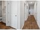 Hallway with wood floors, white doors, leading to a bathroom with a sink, toilet, and shower at 1014 Peridote Way, Ladson, SC 29456