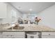 Bright kitchen with stainless steel sink, granite countertops, and a view to the living room at 1014 Peridote Way, Ladson, SC 29456