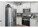 Stainless steel refrigerator and oven with granite countertops and white cabinets in a well lit kitchen at 1014 Peridote Way, Ladson, SC 29456