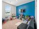 Spacious playroom featuring a vibrant blue wall, entertainment center, and ample space at 1014 Peridote Way, Ladson, SC 29456