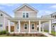 Charming two-story home featuring a welcoming front porch with stately white columns and a well-manicured lawn at 1017 Marsh Royal St, Summerville, SC 29485