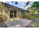 The home features a concrete backyard patio, sliding glass doors, and windows, set against a backdrop of trees and greenery at 105 Moon Shadow Ln, Summerville, SC 29485