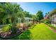 Lush backyard featuring garden area, pergola, mature palm trees, and well-manicured lawn at 105 Northpark Ave, Summerville, SC 29485