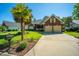 Inviting brick home with manicured lawn, palm trees, and wide driveway leading to a two-car garage at 105 Northpark Ave, Summerville, SC 29485