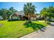 Charming brick home with a well-manicured lawn, palm tree, and inviting two-car garage at 105 Northpark Ave, Summerville, SC 29485