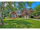 Beautiful brick home with a green lawn, mature trees, and blue shutters, creating a welcoming curb appeal at 106 Sago Palm Ct, Summerville, SC 29483