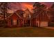 Charming two-story brick home with a well-manicured lawn and inviting front porch at dusk at 106 Sago Palm Ct, Summerville, SC 29483