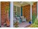 Covered front porch with chairs, potted plants, and a ceiling fan at 106 Sago Palm Ct, Summerville, SC 29483