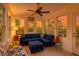 Cozy sunroom with a blue sectional couch, ceiling fan, and multiple windows offering natural light at 106 Sago Palm Ct, Summerville, SC 29483