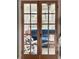 Sunroom with blue sofa and white wood floors is viewed through a set of glass paned French doors at 106 Sago Palm Ct, Summerville, SC 29483