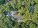 An aerial view of a wooded home with mature trees, tennis court and a lush lot at 108 E Walker Dr, Summerville, SC 29483