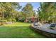 Serene backyard featuring lush lawn, mature trees, and a charming brick patio at 108 E Walker Dr, Summerville, SC 29483