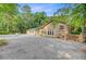 Charming home with a brick facade and bright windows, nestled on a wooded lot with a gravel driveway at 108 E Walker Dr, Summerville, SC 29483