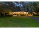 Inviting brick home illuminated at dusk, showcasing manicured landscaping and a charming, winding driveway at 108 E Walker Dr, Summerville, SC 29483
