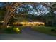 Picturesque brick home with manicured landscaping, illuminated at dusk, and a welcoming driveway at 108 E Walker Dr, Summerville, SC 29483