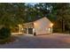 Two-car garage featuring dark gray doors and exterior lighting on a gravel driveway surrounded by woods at 108 E Walker Dr, Summerville, SC 29483