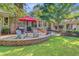 Charming brick patio with red umbrella, perfect for outdoor dining and relaxation at 108 E Walker Dr, Summerville, SC 29483