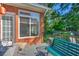 Brick home's back porch featuring a window, table, bench and a green, fenced-in backyard at 1111 Ole South Ct, Moncks Corner, SC 29461