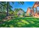 Expansive backyard with a brick house, manicured lawn, and flower beds at 1111 Ole South Ct, Moncks Corner, SC 29461