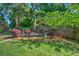 Landscaped backyard featuring a patio area with outdoor seating and lush plantings at 1111 Ole South Ct, Moncks Corner, SC 29461