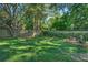 Well-maintained backyard featuring a green lawn, mature trees, and a privacy fence at 1111 Ole South Ct, Moncks Corner, SC 29461