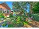 Manicured backyard featuring a bird bath, flowerbeds, and greenery with a partial view of the brick house at 1111 Ole South Ct, Moncks Corner, SC 29461