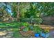 Lush backyard with flowerbeds, a bird bath, and a well-maintained lawn enclosed by a wooden fence at 1111 Ole South Ct, Moncks Corner, SC 29461