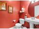 Stylish powder room featuring a pedestal sink and vibrant red walls at 1111 Ole South Ct, Moncks Corner, SC 29461